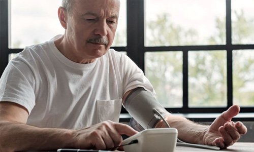 Concerned older man checking his blood pressure at home