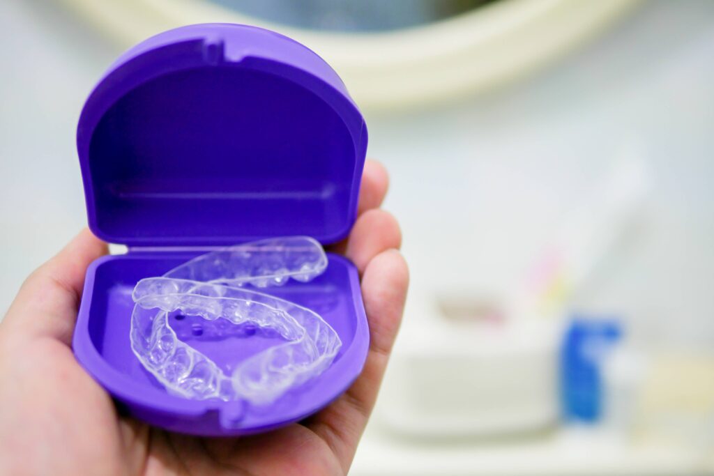 Clear orthodontic retainers in purple case